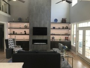 G & J Remodeled livingroom, with tiled fireplace, stained cabinets and matching floating shelves