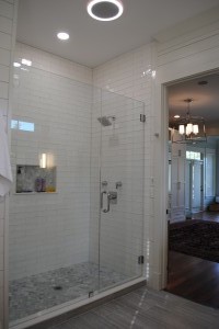 Mt. Pleasant, Master Bathroom custom walk-in shower with subway style white wall tiles and grey marble hexagonal floor tiles. Moen 90 Degree square showerhead.  Round Fan light with bluetooth speaker.